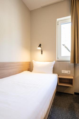 a bedroom with a white bed and a window at May Hotel Mayschoß in Mayschoß