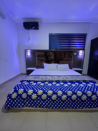 a bedroom with a large bed with a blue and white blanket at Ungess Global Ventures in Iju Junction