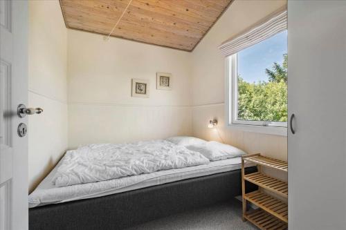 a bedroom with a bed and a window at 0060-Romo-Lakolk-33 in Lakolk