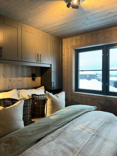 a bedroom with a large bed and a window at Modern Family Cabin In Norefjell Ski-Inout in Surteberg