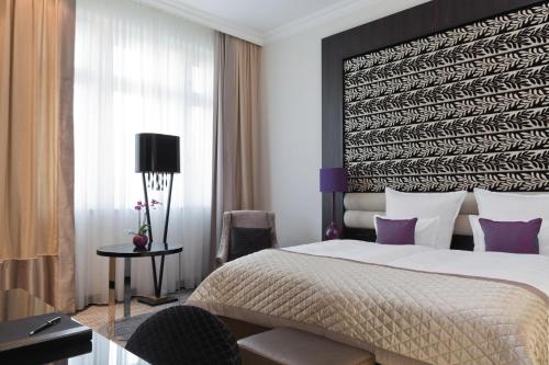 a bedroom with a large bed and a window at Steigenberger Icon Grandhotel Handelshof Leipzig in Leipzig