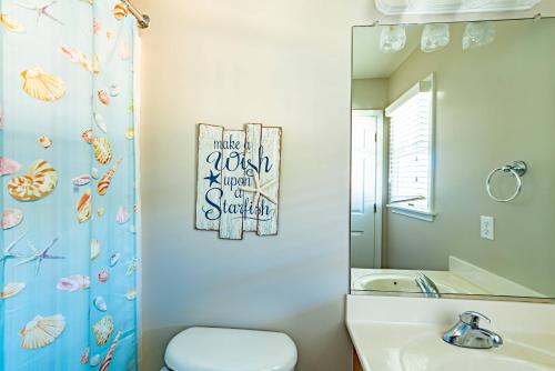 a bathroom with a toilet and a sink and a mirror at Family Tradition in Duck