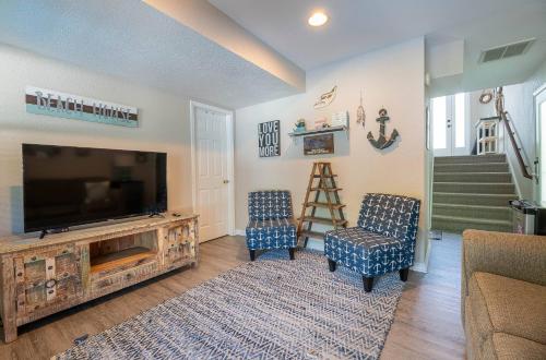 a living room with a flat screen tv and two chairs at Family Tradition in Duck