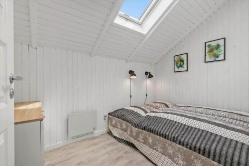 a bedroom with a bed and a skylight at 0294-Romo-Vestergade-3-Ap-57 in Havneby