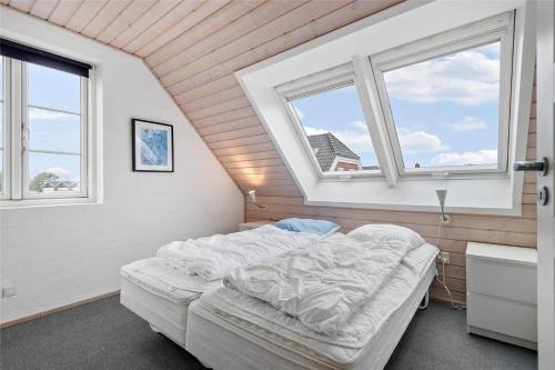 a bedroom with a large white bed and two windows at 0287-Romo-Sonder-Frankel-28 in Havneby