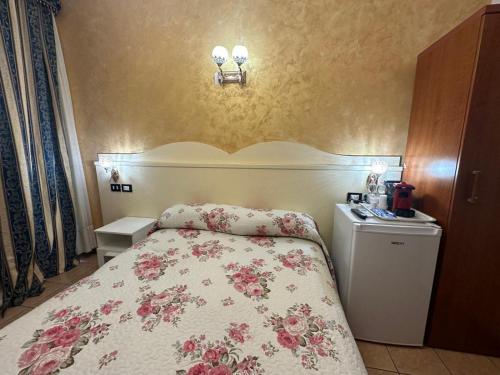 ein Schlafzimmer mit einem Bett mit geblümter Tagesdecke in der Unterkunft Near Termini station in Rom