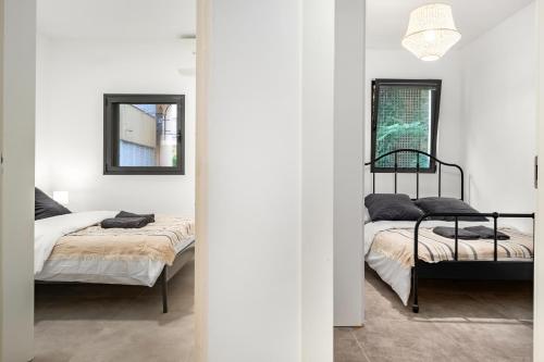 テルアビブにあるLuxury 3BR Sea View and Poolの白い部屋(鏡2つ付)のベッド2台
