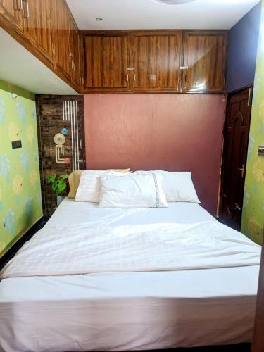 a bedroom with a large white bed with wooden cabinets at Sainathan Residency in Puducherry