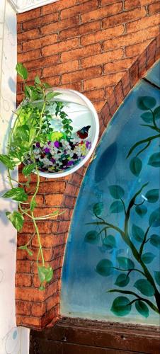 a bowl of flowers on a wall next to a pond at Sainathan Residency in Puducherry