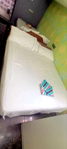 a white bed with a tie sitting on it at Sainathan Residency in Puducherry