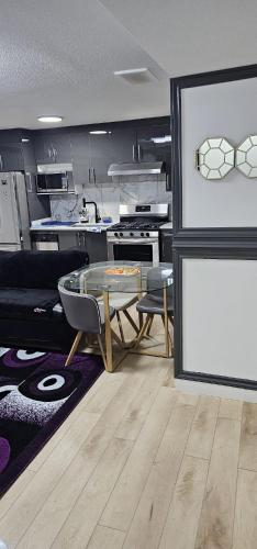 a living room with a table and a kitchen at Newly Built basement suite in Edmonton