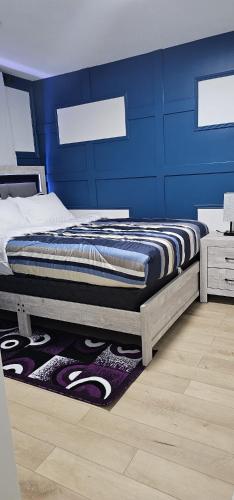 a bedroom with a bed with a blue wall at Newly Built basement suite in Edmonton