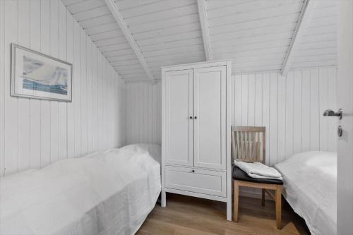 1 dormitorio con 1 cama, 1 silla y 1 armario en 0278-Romo-Vestergade-3-Ap-23, en Havneby