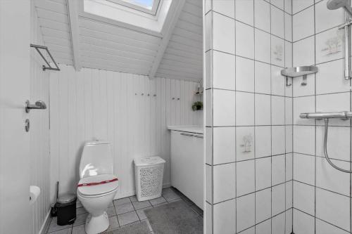Un baño blanco con inodoro y ducha. en 0278-Romo-Vestergade-3-Ap-23, en Havneby