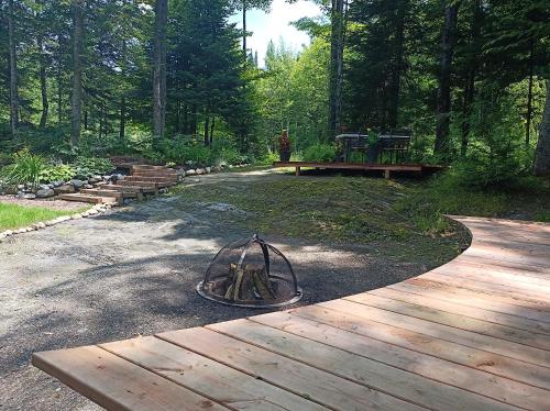 a fire pit on a wooden deck in a park at Hummingbird Room - Modern & Cozy with Bistro Area in Mansonville
