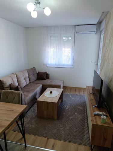 a living room with a couch and a coffee table at Stan na dan Bratunac -Apartman in Podgradac