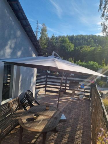 a picnic table with an umbrella on a patio at Apartament exclusive Głuszyca in Głuszyca