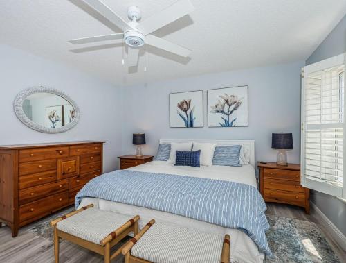 Un dormitorio con una cama y un ventilador de techo. en Peaceful Beachfront 30' Deck with Sweeping Views, en Clearwater Beach