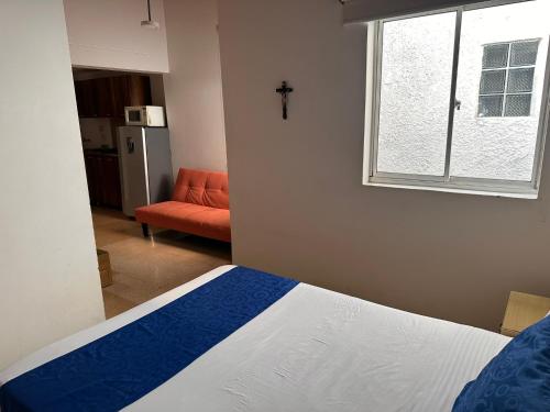 a bedroom with a bed and a window and a couch at Amoblados Medellín Laureles in Medellín