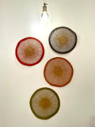 a group of three umbrellas hanging on a wall at CALEO Guest House in Taurisano