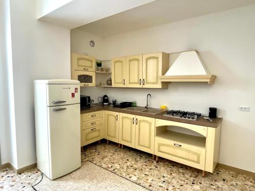 a kitchen with a white refrigerator and a sink at CALEO Guest House in Taurisano