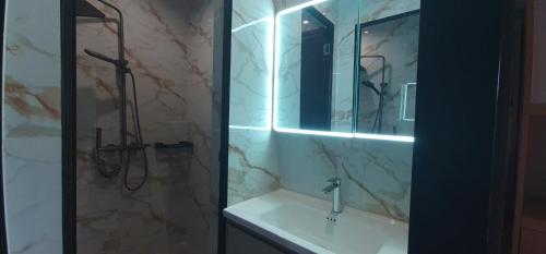 a bathroom with a sink and a shower with a mirror at BuenaSentro Hostel in Manila