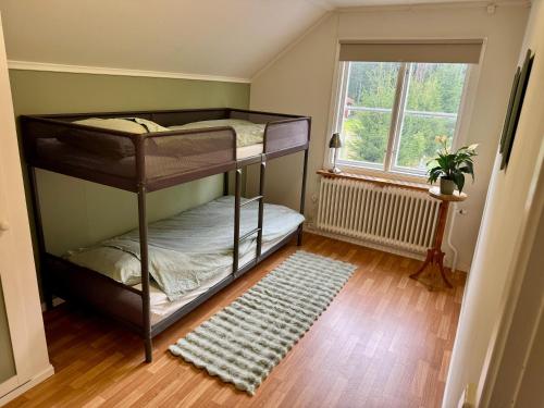 a room with two bunk beds and a window at House near forest and water in Hagfors
