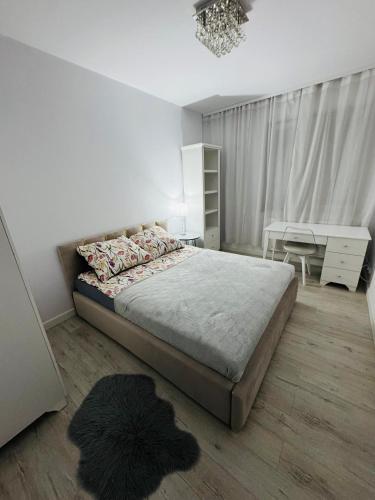 a bedroom with a large bed and a desk at LUX Apartament in Suwałki