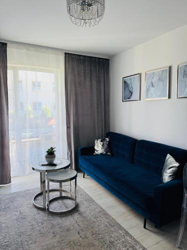 a living room with a blue couch and a table at LUX Apartament in Suwałki