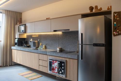 a kitchen with a stainless steel refrigerator at Villa Naluri - Seu Refúgio a 50 metros da praia em Japaratinga in Japaratinga
