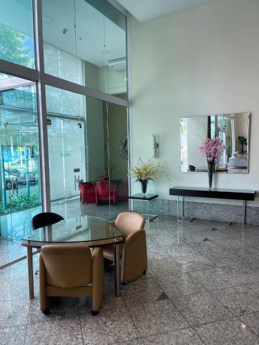 a lobby with a glass table and two chairs at Praia do canto Apart Hotel - Apto 203 Varanda Lateral com Vista Mar in Vitória