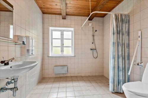 een witte badkamer met een wastafel en een douche bij 0397-Romo-Engvej-40 in Rømø Kirkeby