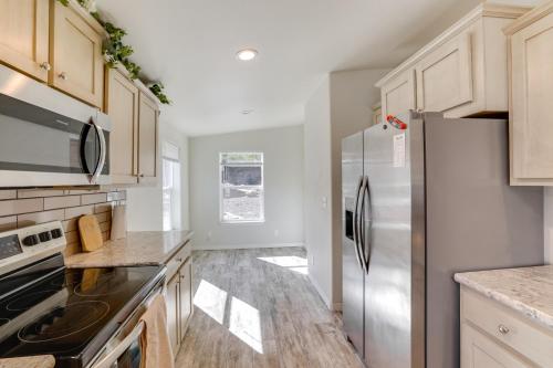 a kitchen with a stainless steel refrigerator and wooden cabinets at Mtn-View Gem with Outdoor Entertainment in Ahsahka! 