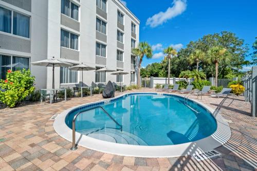 a swimming pool with chairs and a building at Spark by Hilton Orlando near Universal in Orlando