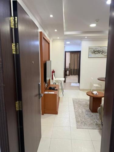 a room with a hallway with a door and a television at جراند سيزون للشقق الفندقية الخبر Grand Season Hotel Apartments in Al Khobar in Al Khobar