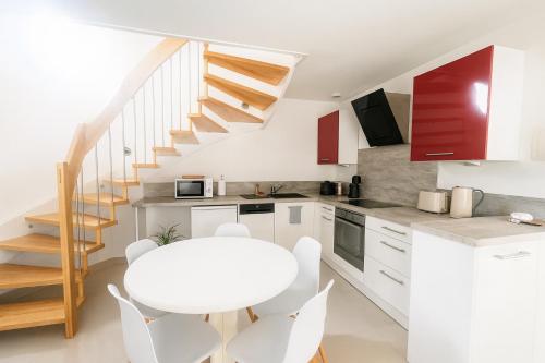 a kitchen with a white table and a white table and chairs at l'abri du bonheur in Lampertheim