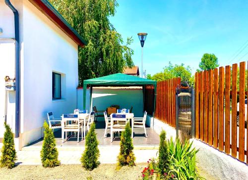a patio with tables and a green umbrella at Vila ANA in Cluj-Napoca