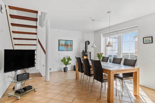 a dining room with a table and chairs and a television at 0381-Romo-Sonder-Frankel-44 in Havneby