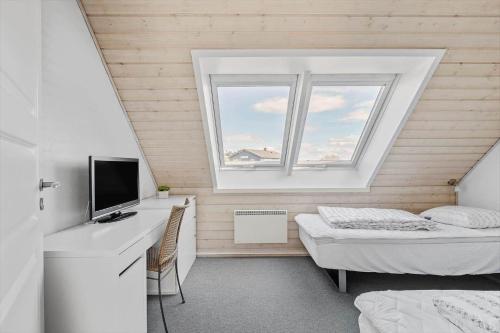 a bedroom with a bed and a desk with a television at 0381-Romo-Sonder-Frankel-44 in Havneby