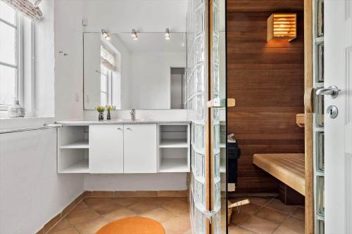 a kitchen with white cabinets and a wooden wall at 0381-Romo-Sonder-Frankel-44 in Havneby