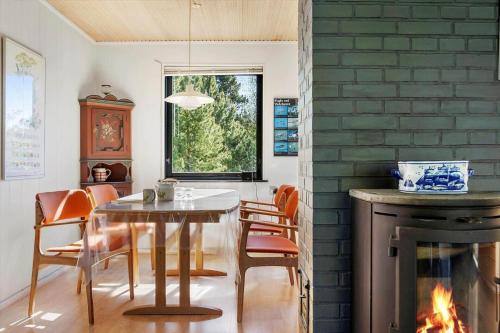 a dining room with a table and a fireplace at 0204-Romo-P-S-Carlsvej-6 in Tagholm