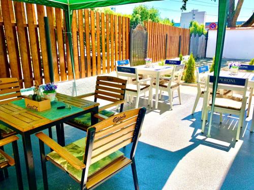a patio with tables and chairs and a green umbrella at Vila ANA in Cluj-Napoca