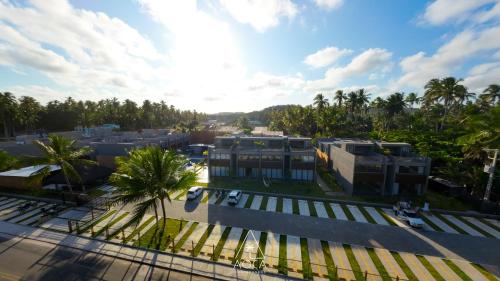 an overhead view of a campus with palm trees and buildings at Villa Naluri - Seu Refúgio a 50 metros da praia em Japaratinga in Japaratinga