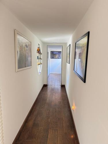 a hallway with three paintings on the walls and a door at Beautiful House with Fantastic view in Azusa in Azusa