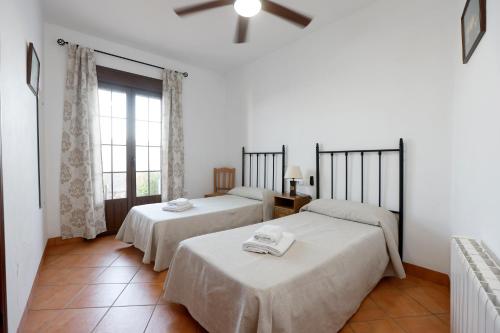 a bedroom with two beds and a window at Casa Rural La Fuente in Segura de León