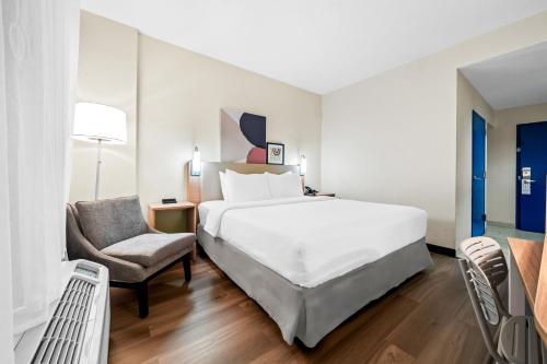 a bedroom with a large bed and a chair at Spark by Hilton Orlando near Universal in Orlando