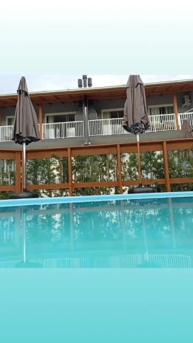 a building with a swimming pool with two umbrellas at Seven76Residence in Barra Velha