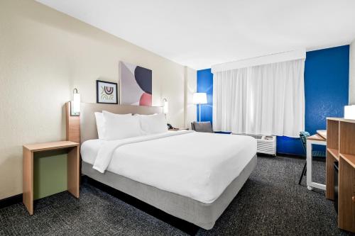 a hotel room with a large bed and a desk at Spark by Hilton Orlando near Universal in Orlando