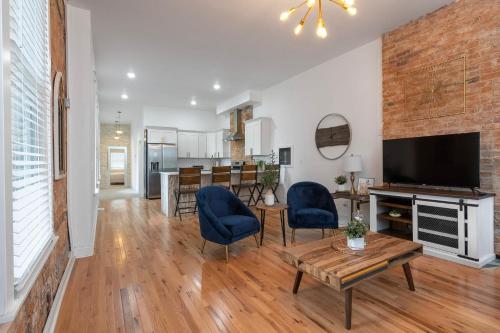 a living room with a television and a table and chairs at Lee Street Retreat - Best of Covington in Covington