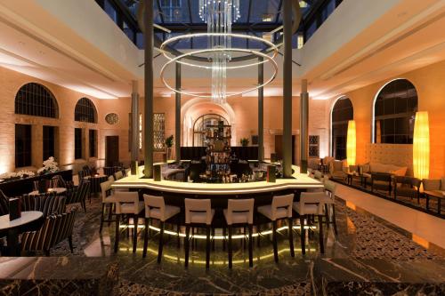 a restaurant with a table and chairs in a building at Steigenberger Icon Grandhotel Handelshof Leipzig in Leipzig